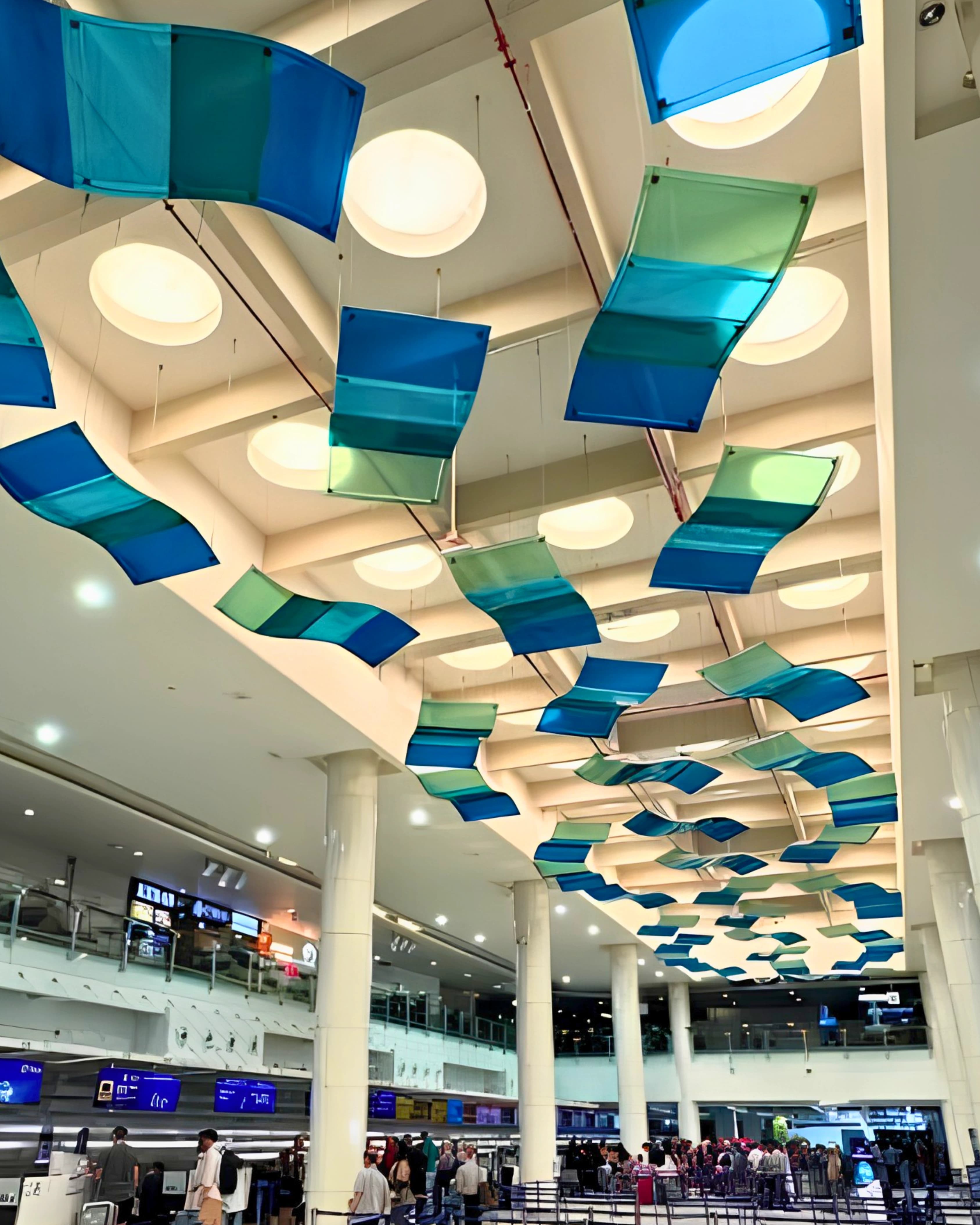 Wave-like blue and green fabric panels suspended above the check-in hall at Phuket International Airport