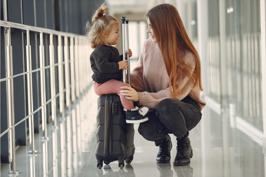 Parents with young children and luggage at an airport arrivals area