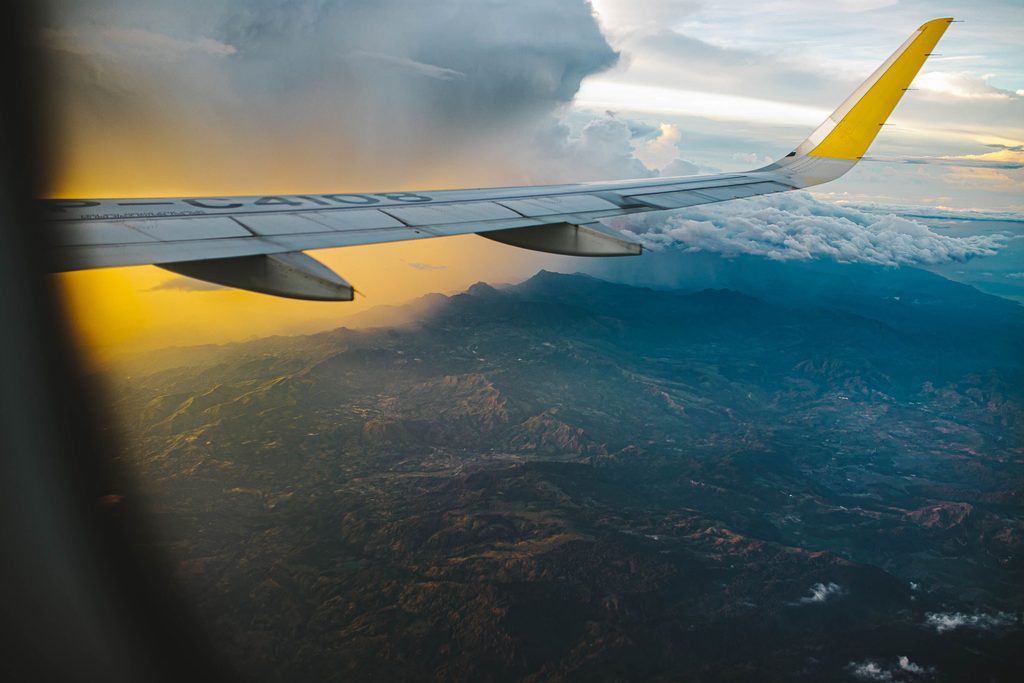 View from a plane window over green hills on a flight from Bangkok to Chiang Mai